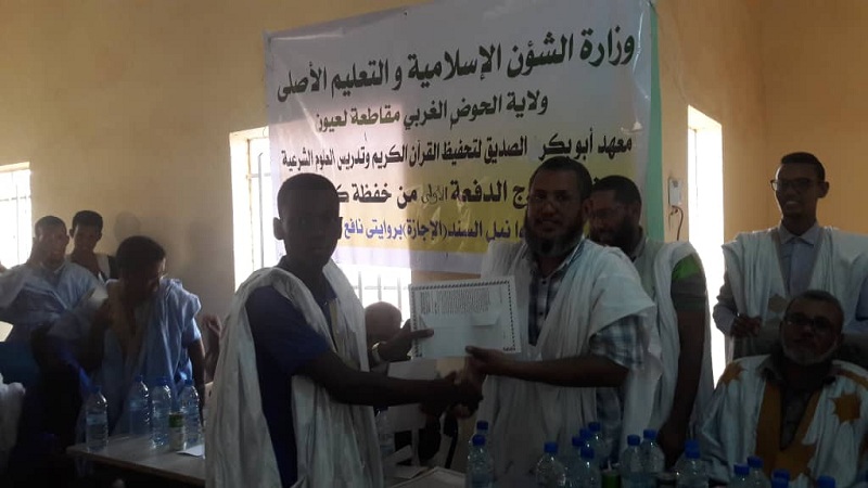 أحد خريجي المعهد يتسلم شهادة تكريمه خلال الحفل