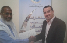 أحد المشاركين في الدورة يتسلم إفادة من مقدم الدورة 