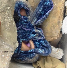 جثة الرضيع قبيل انتشالها من بين الحجارة التي وضعت عليها