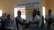 أحد خريجي المعهد يتسلم شهادة تكريمه خلال الحفل